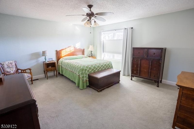 bedroom featuring light colored carpet, ceiling fan, and a textured ceiling