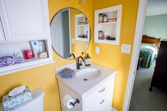 half bath featuring toilet, built in features, a textured ceiling, and vanity