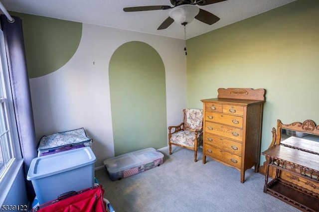 interior space with ceiling fan and carpet flooring