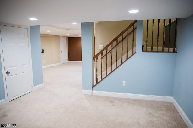 spare room with carpet floors, stairway, and baseboards