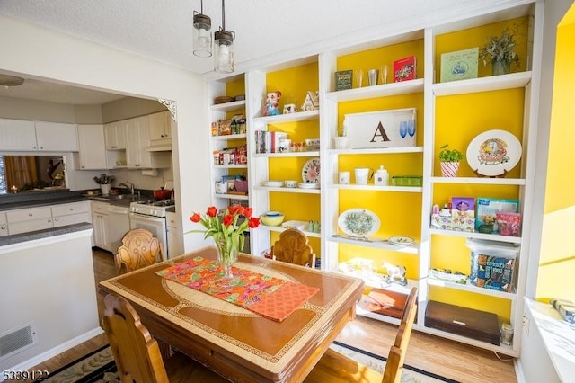 dining area featuring wood finished floors and visible vents