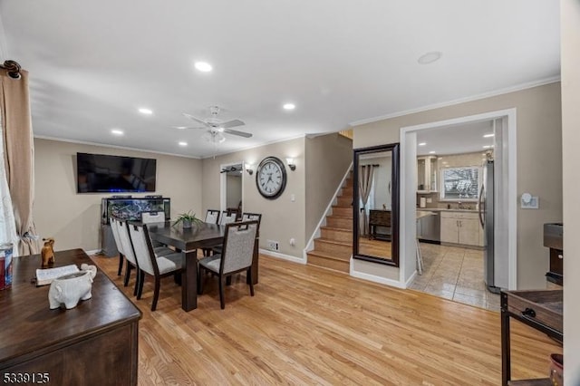 dining space featuring light hardwood / wood-style floors, crown molding, and ceiling fan