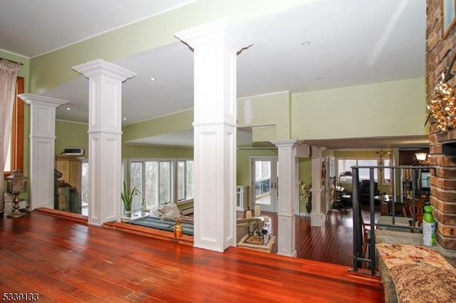 interior space featuring decorative columns and wood finished floors