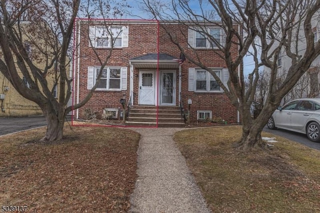 view of property featuring entry steps and brick siding