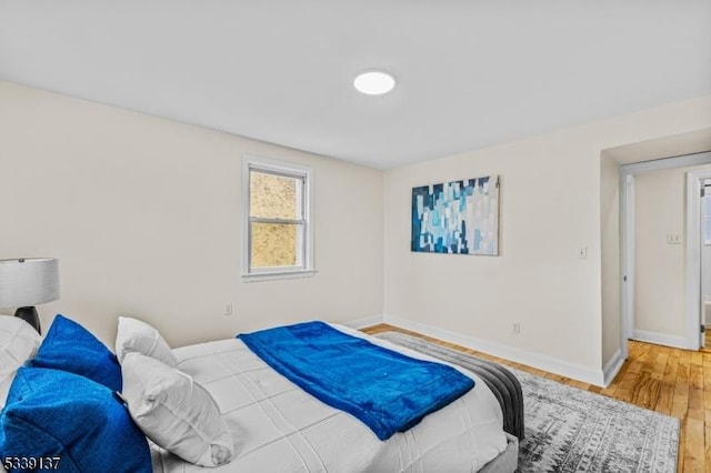 bedroom with baseboards and wood finished floors