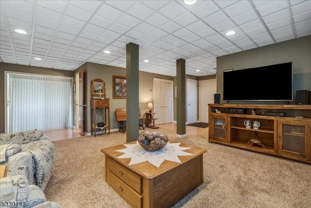 living room featuring recessed lighting, a drop ceiling, and light colored carpet