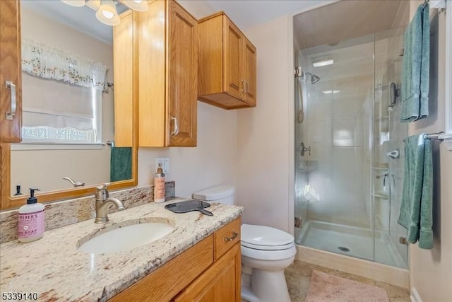 bathroom with tile patterned floors, toilet, a stall shower, and vanity