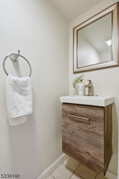 bathroom with tile patterned flooring, vanity, and baseboards