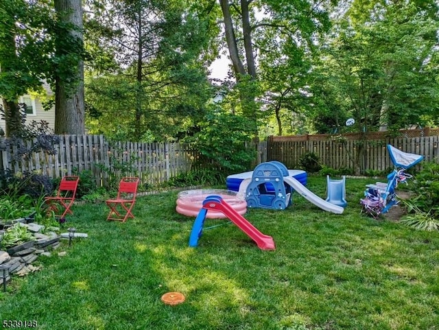 view of play area with a yard and fence