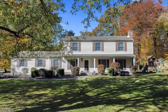 view of front of property featuring a front yard, a playground, and a chimney