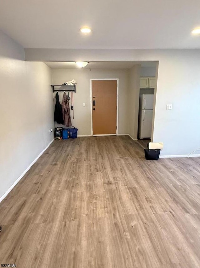 unfurnished room with light wood finished floors, recessed lighting, and baseboards