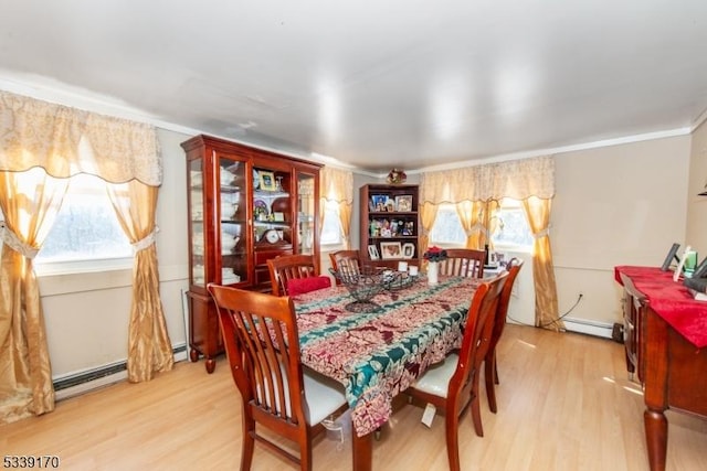 dining space with light wood-style flooring, ornamental molding, and baseboard heating