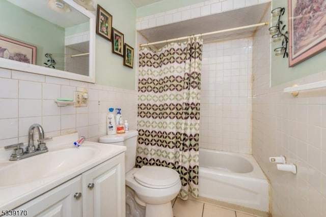 full bathroom featuring tile patterned flooring, shower / tub combo with curtain, tile walls, and vanity