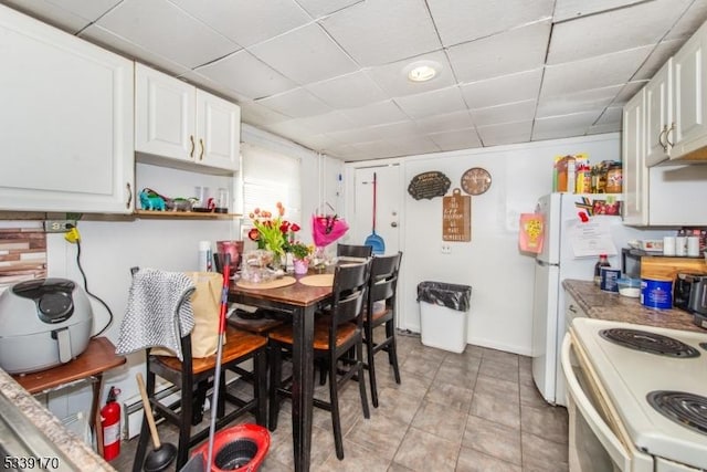 kitchen featuring electric stove, white cabinetry, a drop ceiling, and open shelves