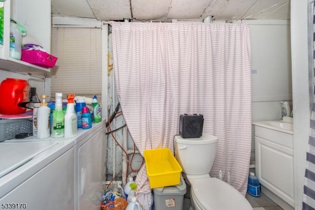 interior space with toilet, washing machine and dryer, and vanity