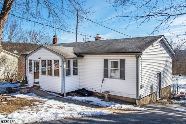 view of front of home featuring roof with shingles and a chimney