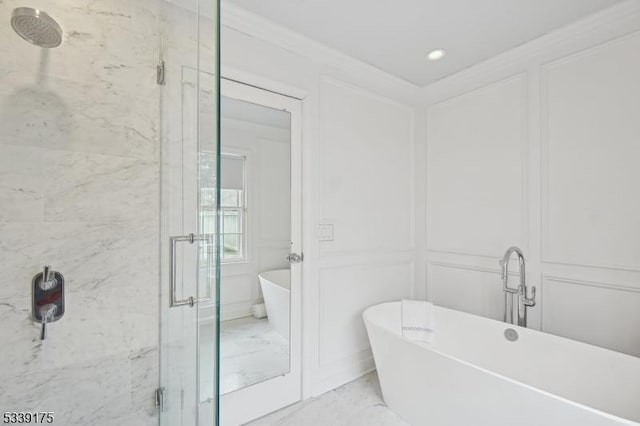 bathroom with a soaking tub, a shower stall, and a decorative wall