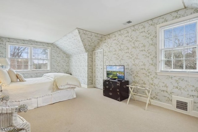 carpeted bedroom featuring wallpapered walls, multiple windows, and visible vents