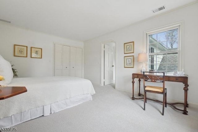 bedroom featuring a closet, visible vents, and light colored carpet