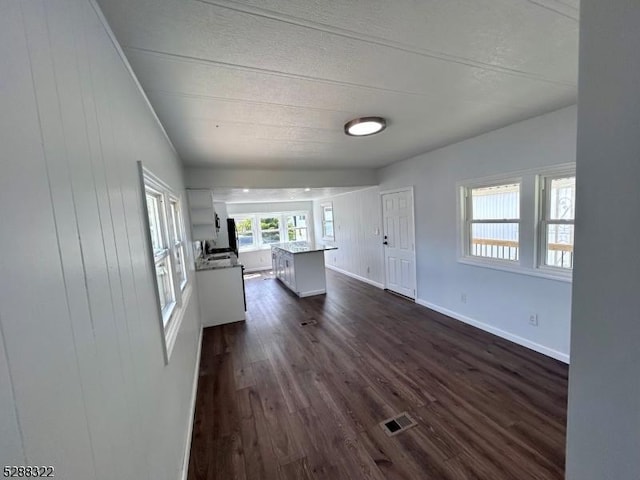 unfurnished living room with dark wood-type flooring