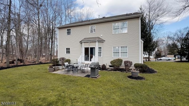 rear view of property featuring a patio and a lawn