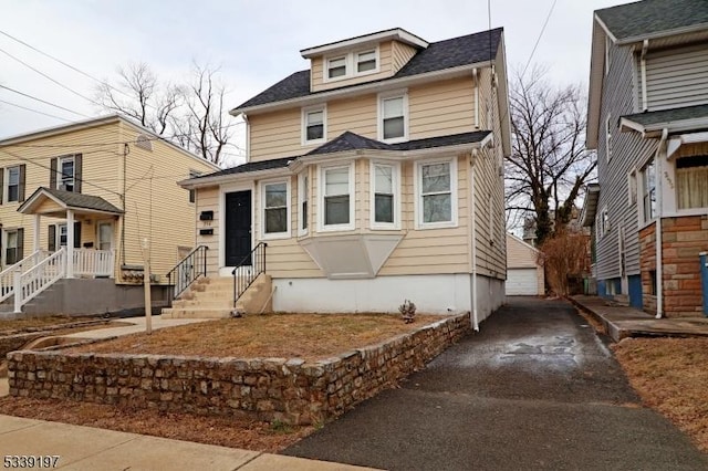 american foursquare style home with entry steps and driveway