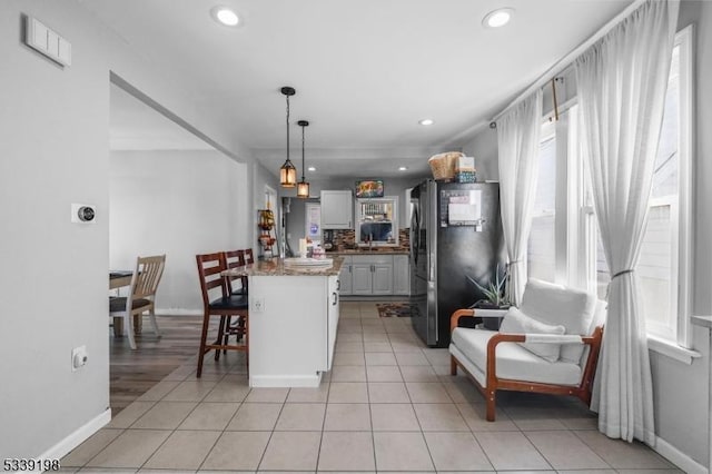 kitchen with recessed lighting, light tile patterned flooring, freestanding refrigerator, and gray cabinetry