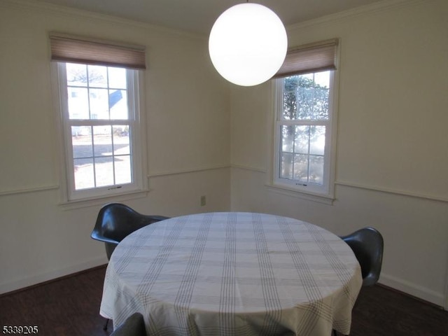 dining room featuring plenty of natural light, crown molding, and dark hardwood / wood-style flooring