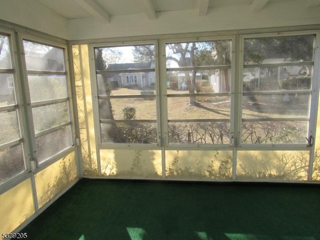 unfurnished sunroom with beam ceiling