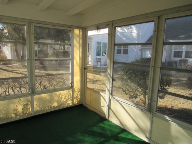 unfurnished sunroom with plenty of natural light and beam ceiling