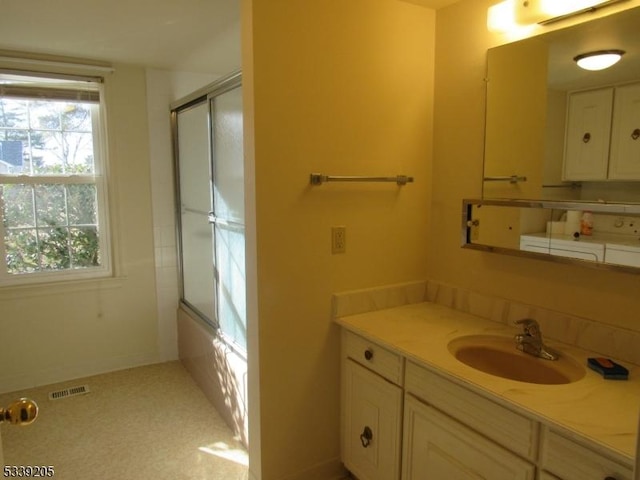 bathroom with bath / shower combo with glass door and vanity