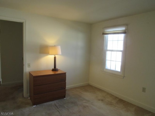 spare room featuring dark colored carpet