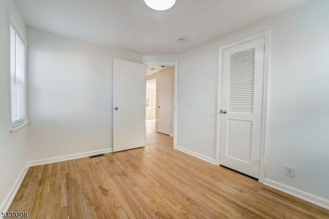 unfurnished bedroom with light hardwood / wood-style flooring and a closet