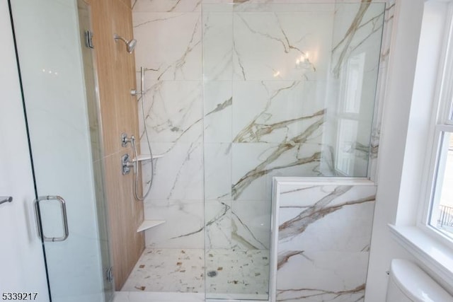 bathroom featuring toilet and a marble finish shower