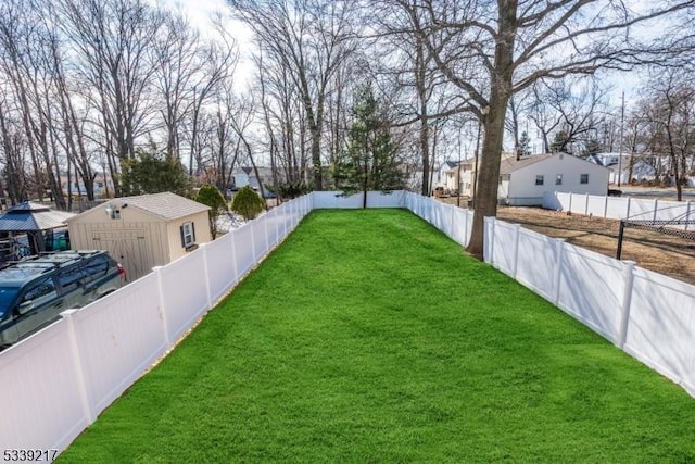 view of yard with a fenced backyard, a residential view, an outdoor structure, and a shed