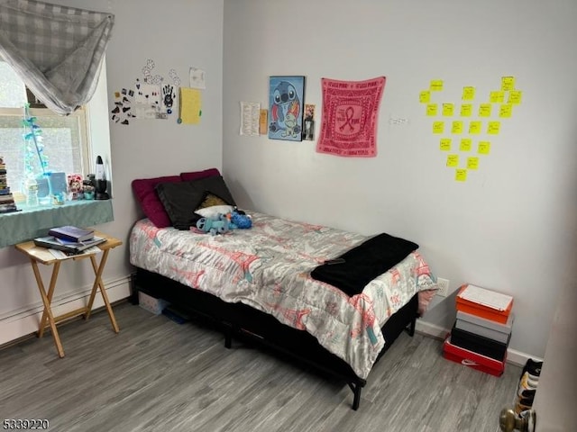 bedroom featuring hardwood / wood-style floors and a baseboard radiator