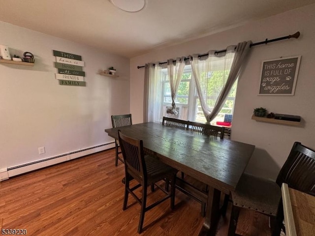 dining room with hardwood / wood-style flooring and a baseboard heating unit