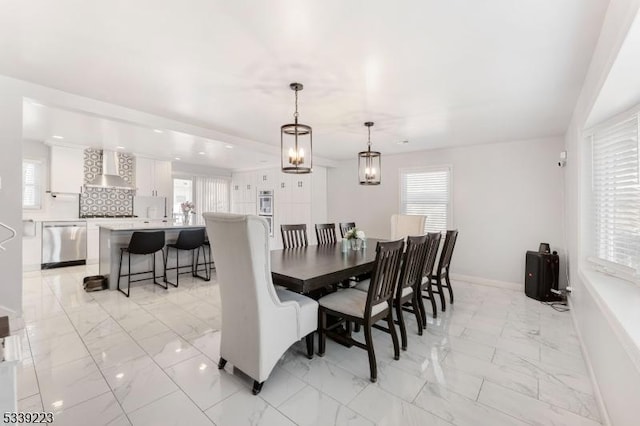 dining room with marble finish floor, plenty of natural light, and baseboards