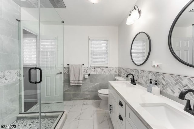 bathroom featuring marble finish floor, a sink, a shower stall, and toilet