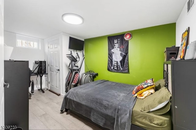 bedroom with light wood-style flooring and visible vents