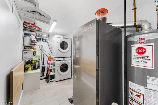 clothes washing area with laundry area, stacked washer / dryer, and gas water heater