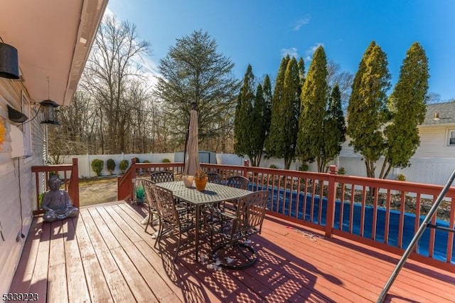 wooden terrace featuring outdoor dining space and a fenced backyard