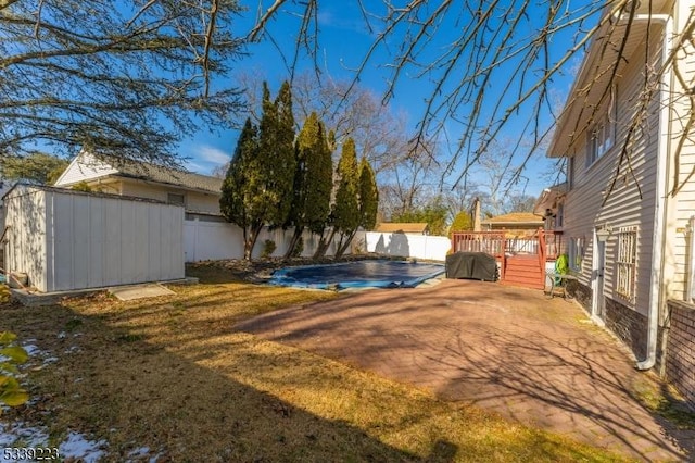 view of yard with a shed, a fenced backyard, and a fenced in pool