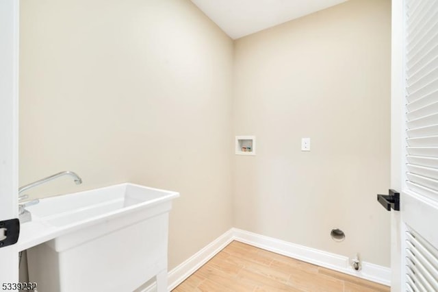 washroom featuring light wood finished floors, laundry area, hookup for a washing machine, and baseboards