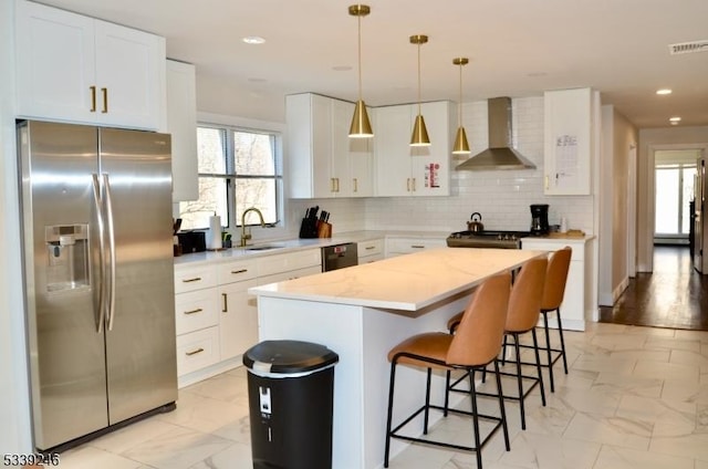 kitchen with visible vents, marble finish floor, wall chimney range hood, stainless steel refrigerator with ice dispenser, and a sink