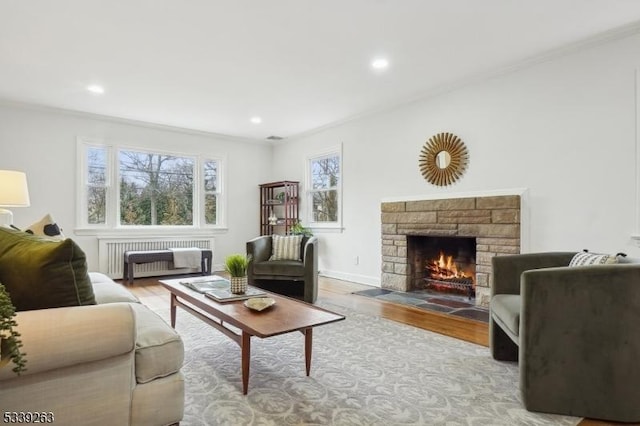 living room with recessed lighting, a fireplace, light wood-type flooring, radiator, and crown molding