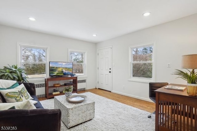 living room featuring baseboards, recessed lighting, wood finished floors, and radiator