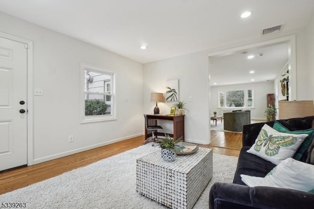 living area with light wood-type flooring, visible vents, and recessed lighting