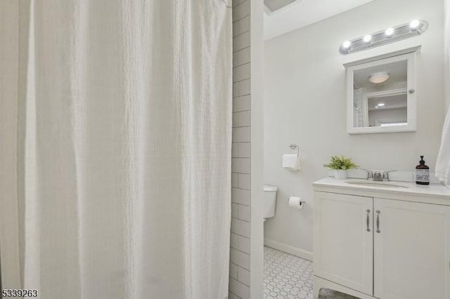 bathroom with a shower with shower curtain, vanity, and baseboards