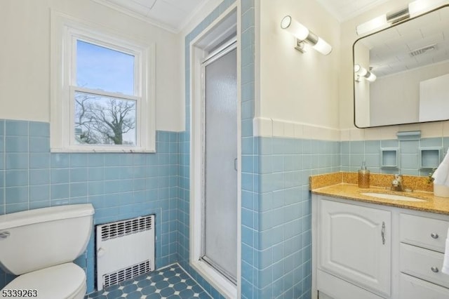 full bathroom with radiator heating unit, ornamental molding, vanity, a shower stall, and tile walls